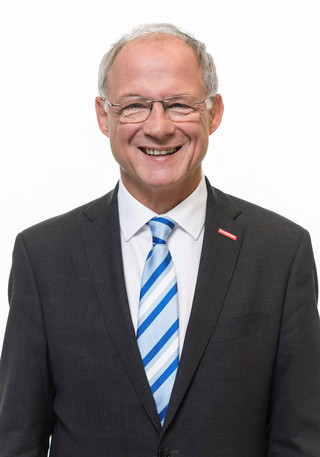 Bernd Wegner lächelt vor weißem Hintergrund