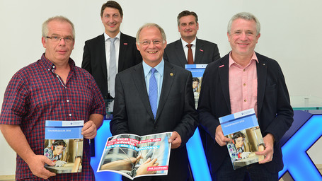 Fünf Männer zeigen den Geschäftsbericht 2016 der Handwerkskammer des Saarlandes