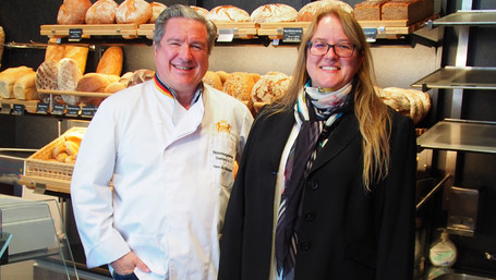 Ein Mann und eine Frau stehen vor einem Regal mit Broten